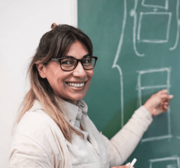 Mathematics teacher writing on chalkboard